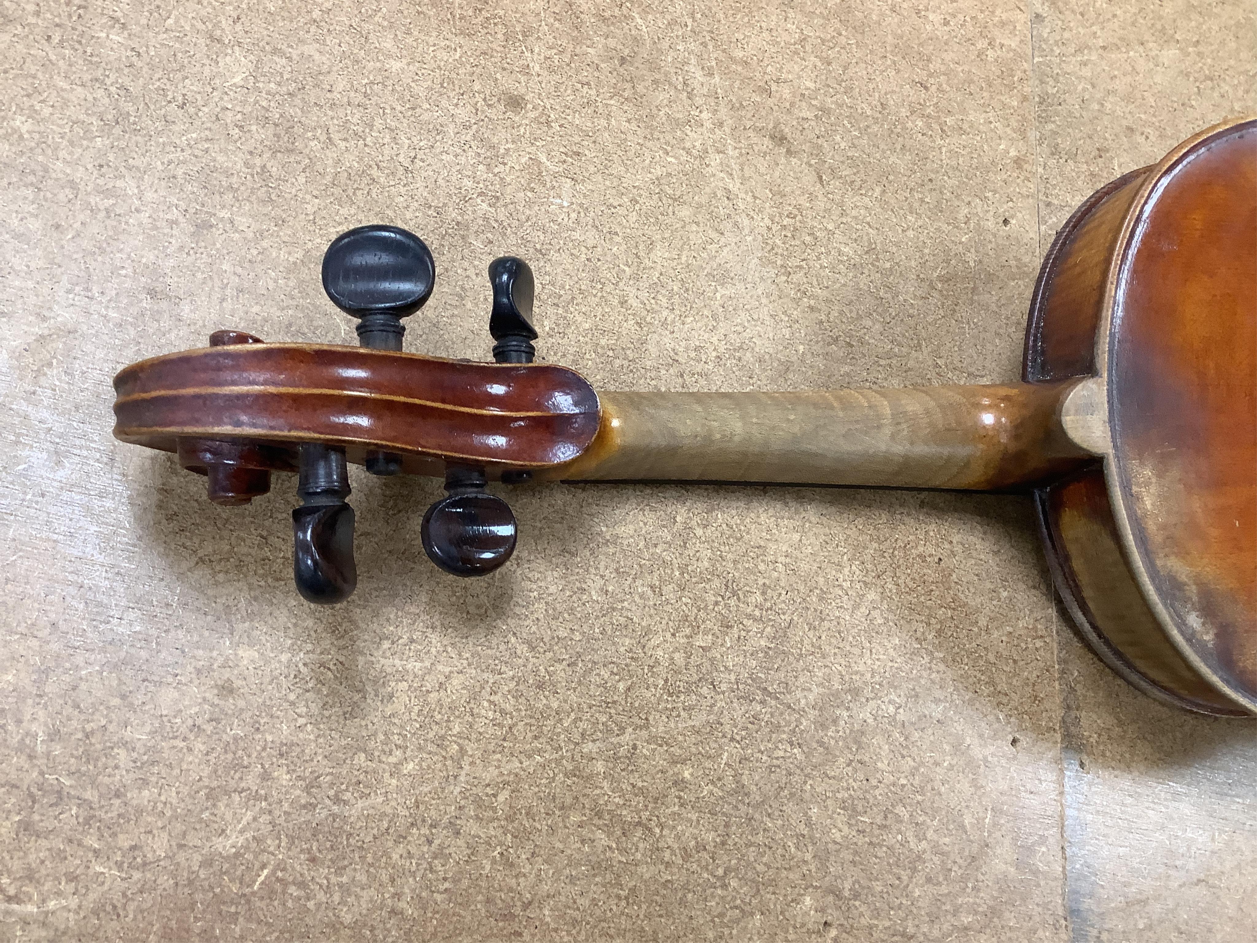 An early 20th century cased violin and cover, 60cm long